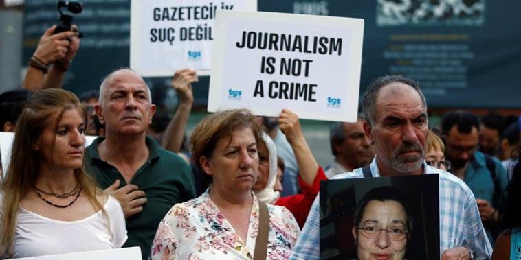 Demonstrators shout slogans during a protest against the arrest of three prominent activists for press freedom, in central Istanbul